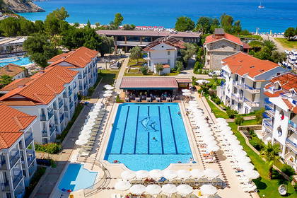 Hotel z basenem, plażą i morzem widziany z góry.