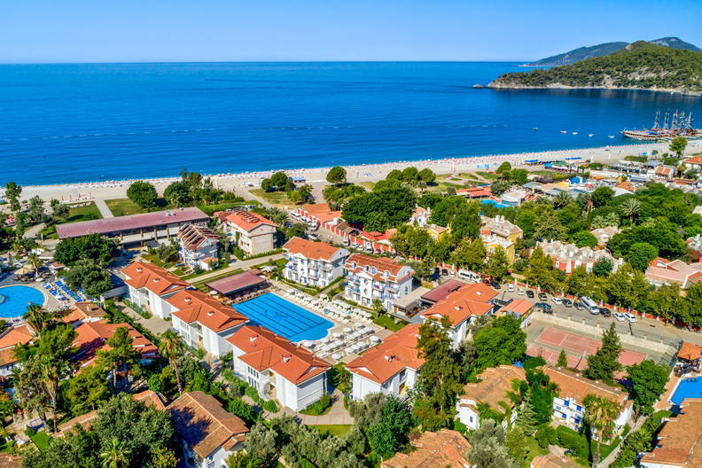 Widok z góry na plażę, kurort i morze z łodziami.