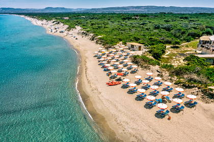 Plaża z lotu ptaka: parasole, leżaki i budka ratownika.