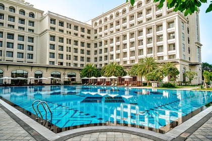 Kompleks hotelowy z basenem w słoneczny dzień.