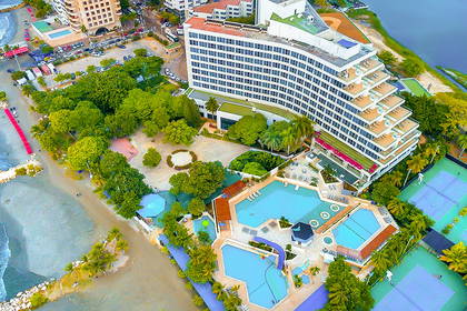 Kompleks hotelowy z basenami, kortami tenisowymi i plażą, widok z lotu ptaka.