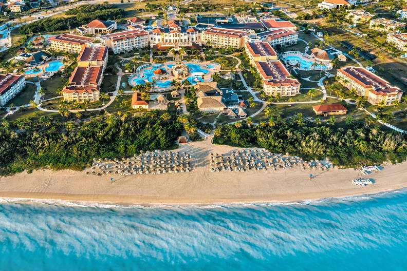 Kurort z plażą i turkusowym oceanem widziany z lotu ptaka.