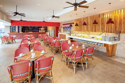 Wnętrze restauracji z czerwonymi krzesłami i stolikami.