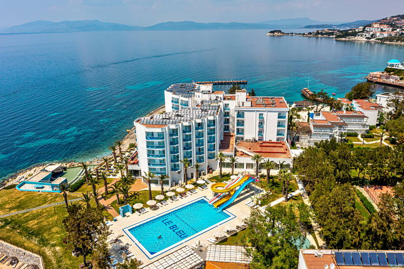 Hotel z basenem i widokiem na morze sfotografowany z lotu ptaka.