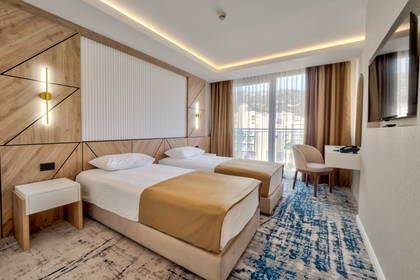 Pokój hotelowy z dwoma łóżkami, biurkiem i krzesłem.