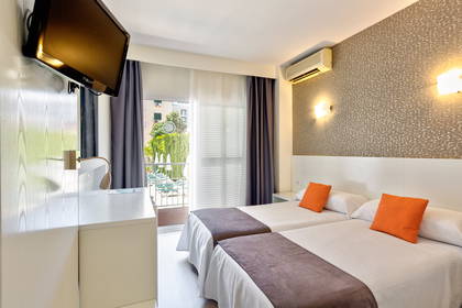 Pokój hotelowy z dwoma łóżkami i balkonem.