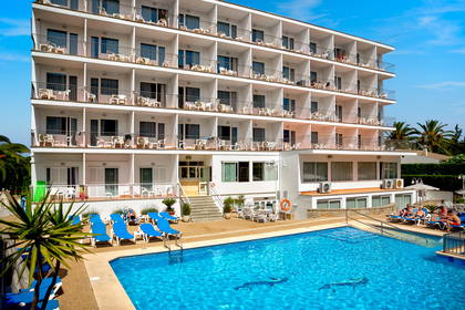 Biały hotel z balkonami i basenem w słoneczny dzień.
