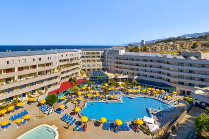 Hotel z basenem, leżakami i widokiem na morze.