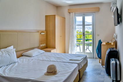 Pokój hotelowy z balkonem, dwa łóżka i widok z okna.