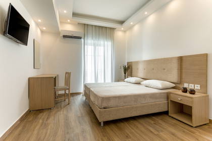 Pokój hotelowy z dwoma łóżkami, biurkiem i telewizorem.