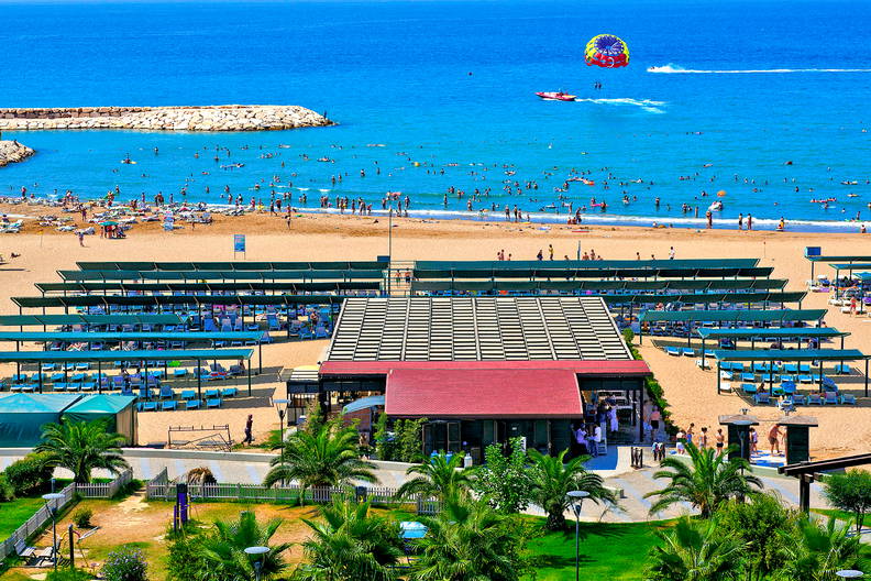 Zatłoczona plaża z parasailingiem, widok z góry.