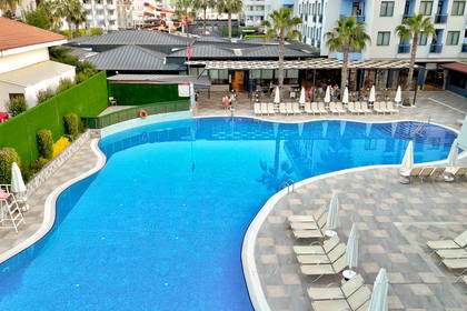Basen hotelowy z leżakami i parasolami, widok z góry.