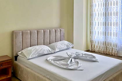 Pokój hotelowy z dużym łóżkiem i zasłoniętym oknem.