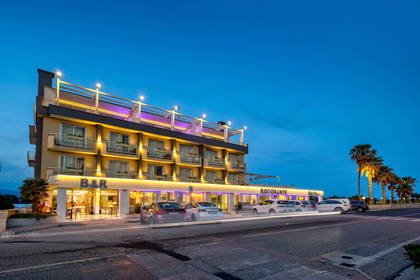 Fasada hotelu z oświetlonym barem i restauracją na parterze.