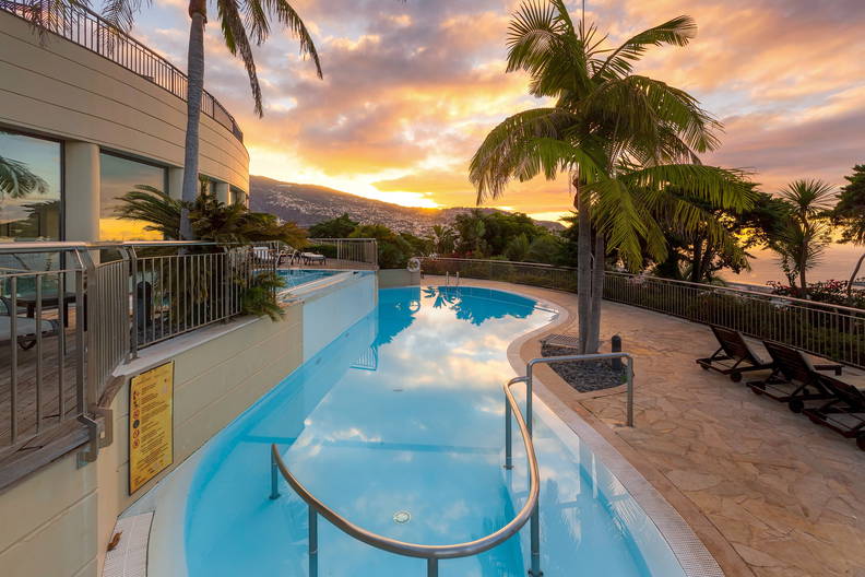 Basen w tropikalnym kurorcie o zachodzie słońca.