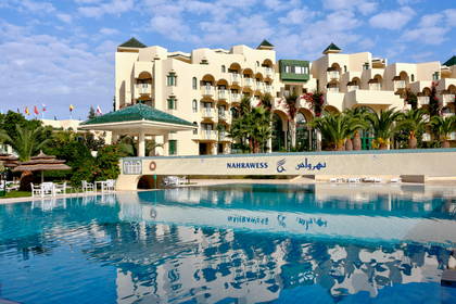 Hotel Nahrawess z basenem w słoneczny dzień.