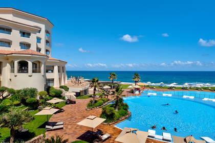 Hotel z basenem przy plaży z widokiem na ocean.