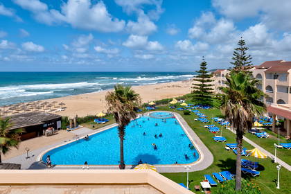 Widok z góry na hotelowy basen, plażę i ocean.