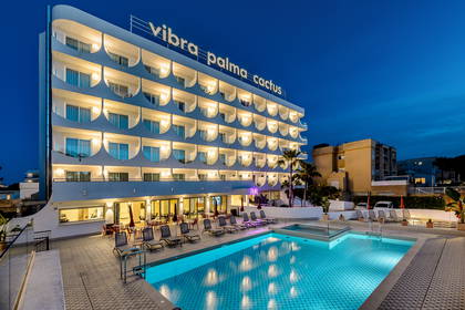 Hotel Vibra Palma Cactus nocą. Widoczny basen i leżaki.