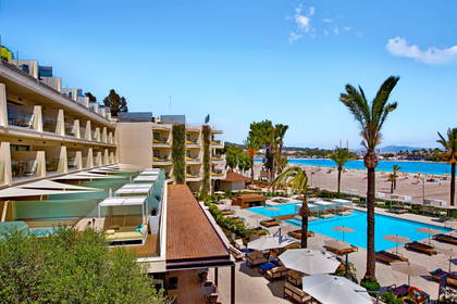 Hotel z basenem, widok z góry. W tle plaża.
