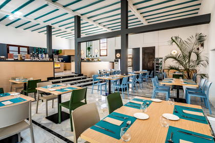 Restauracja. Nakryte stoły i rośliny doniczkowe.