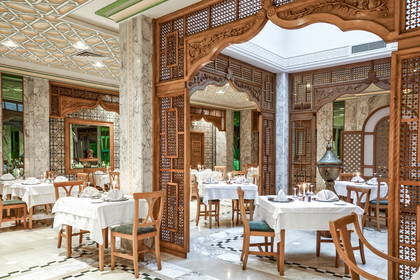 Elegancka restauracja z drewnianymi elementami wystroju i nakrytymi stołami.