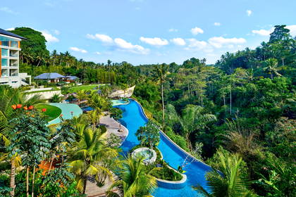 Hotelowy basen bez krawędzi (tzw. infinity pool) otoczony tropikalną roślinnością, widok z góry.
