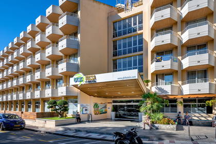 Hotel Oasis Tossa z balkonami i wejściem głównym.