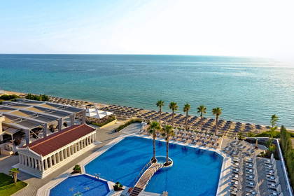 Hotel z basenem, plażą i widokiem na morze.
