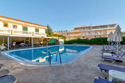 Basen z leżakami i parasolami przy hotelu.