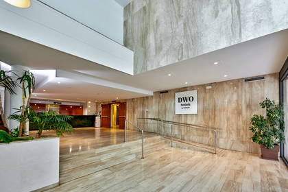Wnętrze hotelu DWO z roślinnością i marmurowymi ścianami.