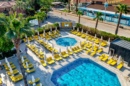 Hotelowy basen z leżakami i parasolami, widok z góry.