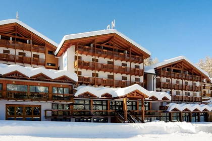 Zimowy hotel z drewnianymi balkonami przykryty śniegiem.