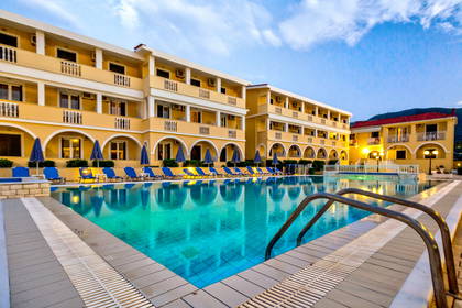 Hotel z basenem i strefą relaksu z leżakami oraz parasolami.