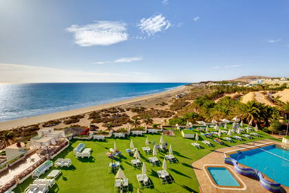 Hotelowy basen, plaża i ocean widziane z góry.