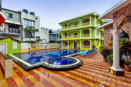 Hotel z basenem i patio wyłożonym kafelkami.