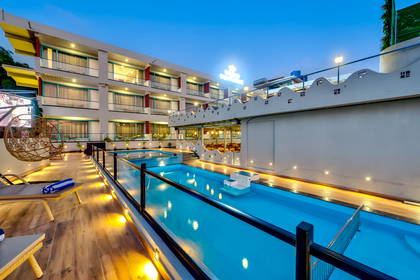 Hotel z basenem oświetlonym nocą.