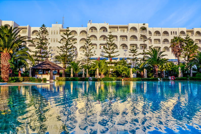 Basen z budynkiem hotelu w tle.