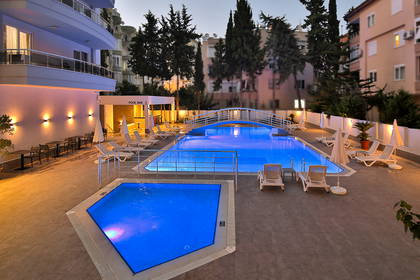 Hotelowy basen z mostkiem i leżakami do opalania.