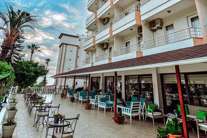 Wielopiętrowy hotel z balkonami i patio pełnym roślin.