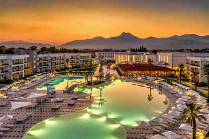 Panorama hotelu z basenami o zmierzchu. W tle widoczne góry.