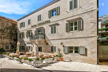 Hotel Croatia z patio i stolikami na zewnątrz.