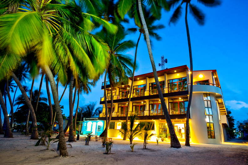 Hotel na plaży otoczony palmami.