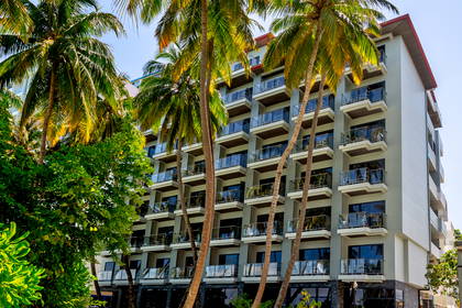 Hotel otoczony palmami w słoneczny dzień.