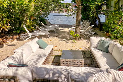 Patio z kanapami i leżakami z widokiem na plażę.
