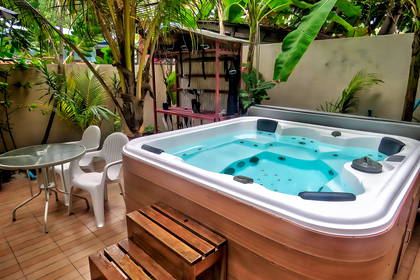 Jacuzzi z drewnianymi schodami i stolikiem.