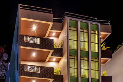 Fasada hotelu Triton Beach Hotel & Spa oświetlona nocą.
