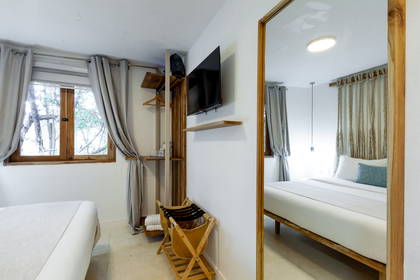 Pokój hotelowy z łóżkiem i lustrem.