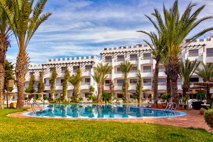 Hotel z basenem i palmami.