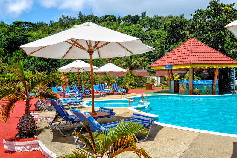 Basen z parasolami, leżakami i barem przy basenie.